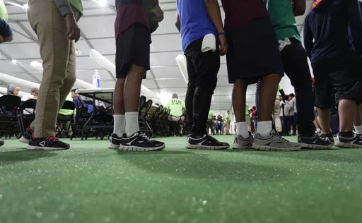 In this July 9, 2019, file photo, immigrants line up in the dinning hall at the U.S. government's newest holding center for migrant children in Carrizo Springs, Texas. The Biden administration plans to partially end the 27-year-old court supervision of how the federal government cares for child migrants, shortly after producing its own list of safeguards against mistreatment. (AP Photo/Eric Gay, File)