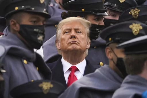 Surrounded by Army cadets, President Donald Trump watches the first half of the 121st Army-Navy Football Game in Michie Stadium at the United States Military Academy, Saturday, Dec. 12, 2020, in West Point, N.Y. Experts in constitutional law and the military say the Insurrection Act gives presidents tremendous power with few restraints. Recent statements by former President Donald Trump raise questions about how he might use it if he wins another term. (AP Photo/Andrew Harnik, File)