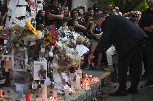 Geoff Payne, right, the father of former One Direction singer Liam Payne, visits a memorial outside the Casa Sur Hotel where the British pop singer fell to his death from a hotel balcony, in Buenos Aires, Argentina, Friday, Oct. 18, 2024. (AP Photo/Mario De Fina)