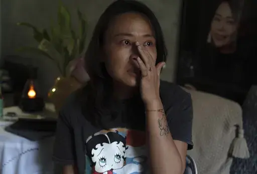 Zhang Peiyi, a Shanghai resident, tears up during an interview at her home in Shanghai on July 31, 2024. (AP Photo/Ng Han Guan)