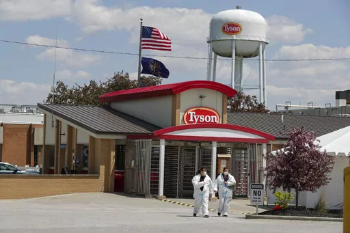 In this May 7, 2020 file photo, workers leave the Tyson Foods pork processing plant in Logansport, Ind.  At the height of the pandemic, the meat processing industry worked closely with political appointees in the Trump administration to stave off health restrictions and keep processing plants open even as COVID-19 spread rapidly among workers, according to a new Congressional report released Thursday, May 12, 2022. (AP Photo/Michael Conroy, File)