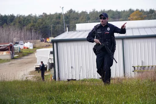 A police officer gives an order to the public during a manhunt for Robert Card at a farm following two mass shootings, Oct. 27, 2023, in Lisbon, Maine. Despite the warning by Card's friend and fellow Army reservist Sean Hodgson, which came alongside a series of other glaring red flags, Army officials discounted the warnings and ultimately did not stop Card from committing Maine's deadliest mass shooting when he killed multiple people in Lewiston. (AP Photo/Robert F. Bukaty, File)
