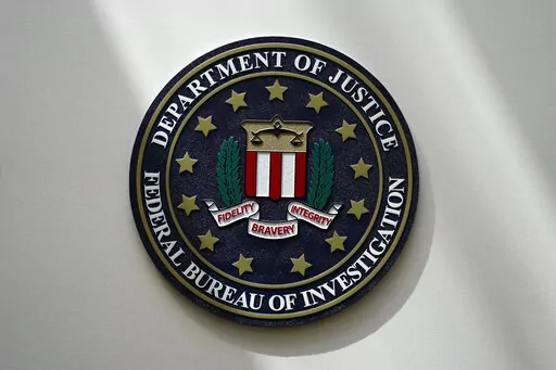 An FBI seal is seen on a wall on Aug. 10, 2022, in Omaha, Neb. The FBI sounded the alarm Monday, Dec. 19, about an explosive increase in teenage boys being targeted online and extorted for money after being tricked into sending sexually explicit pictures. (AP Photo/Charlie Neibergall, File)