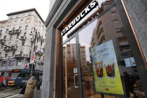 A Starbucks sign advertises the company's Oleato coffee in one of their coffee shops in Milan, Italy, Monday, Feb. 27, 2023. Putting olive oil in coffee is hardly a tradition in Italy, but that didn't stop Starbucks founder and CEO Howard Schultz from launching a series of beverages doing just that in Milan, the city that inspired his coffee house empire. (AP Photo/Antonio Calanni)