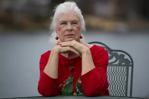 Wanda Olson poses for a photo, Friday, Dec. 17, 2021, in Villa Rica, Ga. When Olson’s son-in-law died in March after contracting COVID-19, she and her daughter had to grapple with more than just their sudden grief. They had to come up with money for a cremation. Even without a funeral, the bill came to nearly $2,000, a hefty sum that Olson initially covered. (AP Photo/Mike Stewart)
