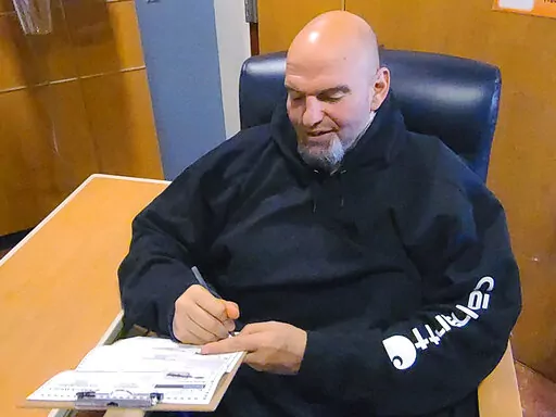 In this photo provided by campaign staffer Bobby Maggio, Pennsylvania Lt. Governor and Democratic Party candidate for a U.S. Senate John Fetterman fills out his emergency absentee ballot for the Pennsylvania primary election in Penn Medicine Lancaster General Hospital in Lancaster, Pa, on Election Day, Tuesday, May, 17, 2022. Fetterman remained in the hospital after suffering a stroke right before the weekend. (Bobby Maggio via AP)