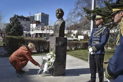 A woman lays a bouquet of flowers at the foot of a statue of former U.S. Secretary of State Madeleine Albright, in Pristina, Kosovo, Thursday, March 24, 2022. A monument in Kosovo, a snake named after her in Serbia. Madeleine Albright was either loved or hated in the Balkans for her pivotal role during the southern European region's wars of the 1990s. Following the former U.S. secretary of state's death on Wednesday at age 84, how her legacy is viewed from the Balkans mostly depends on whether o