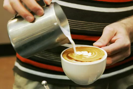 A worker prepares a coffee drink at a shop in Overland Park, Kan., Thursday, Aug. 14, 2008. In a study published in the New England Journal of Medicine on Wednesday, March 22, 2023, healthy volunteers who were asked to drink coffee or skip it on different days showed no signs of an increase in a certain type of heart rhythm after sipping the caffeinated drinks, although they did walk more and sleep less. (AP Photo/Orlin Wagner)