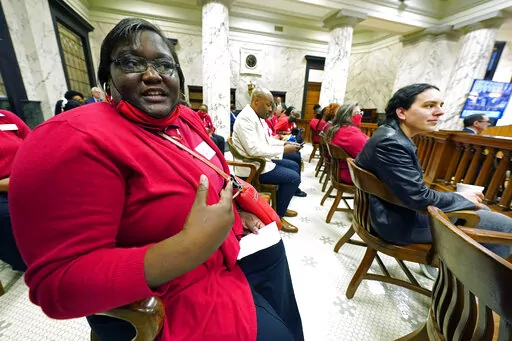 Elementary school teacher LaKristie Barner from Itta Bena, Miss., was one of several teachers that monitored a meeting of the education conferees from both the House and Senate, Wednesday, March 16, 2022, as the lawmakers sought a compromise on their separate teacher pay bills at the Mississippi Capitol in Jackson. (AP Photo/Rogelio V. Solis)