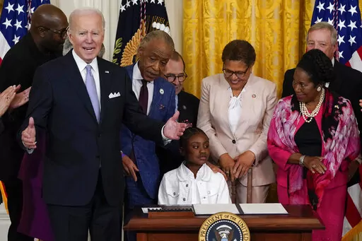 President Joe Biden speaks as Gianna Floyd, the daughter of George Floyd, sits in the chair after Biden signed an executive order in the East Room of the White House, Wednesday, May 25, 2022, in Washington. The order comes on the second anniversary of George Floyd's death, and is focused on policing. (AP Photo/Alex Brandon)