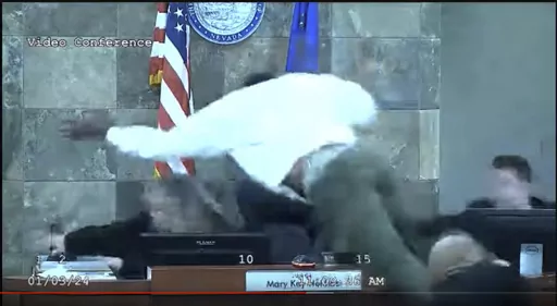 In this image from video provided by the Clark County District Court, a defendant identified by court officials and records as Deobra Redden is seen launching over the desk of Judge Mary Kay Holthus during his sentencing in a felony battery case on Wednesday, Jan. 3, 2024 in Las Vegas. Redden, who was captured in courtroom video leaping over a judge's bench and attacking her, touching off a bloody brawl, is scheduled to appear before her again Monday morning, Jan. 8, 2024. (Clark County District