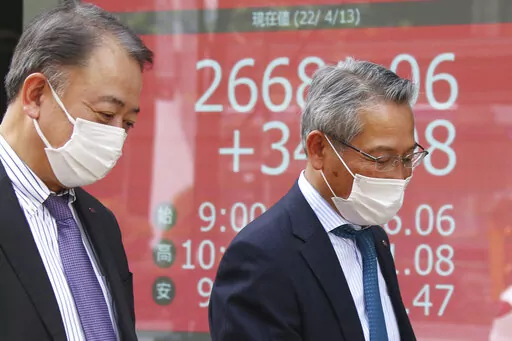 People walk by an electronic stock board of a securities firm in Tokyo, Wednesday, April 13, 2022. Asian shares were mostly higher Wednesday on hopes that the curbs on U.S. interest rates may moderate after new data showed signs of slowing inflation. Benchmarks rose in early trading in Japan, South Korea and Australia, while slipping in China. (AP Photo/Koji Sasahara)