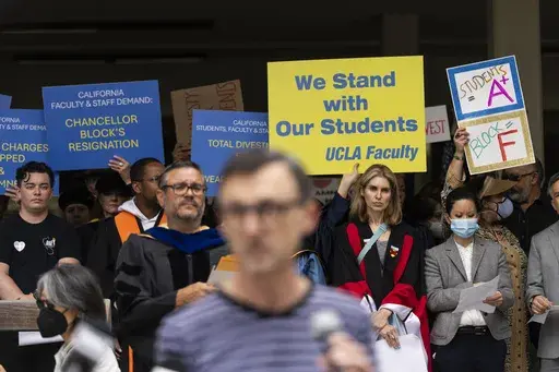 UCLA faculty and staff members hold up signs during a news conference at UCLA in Los Angeles, Thursday, May 9, 2024. (AP Photo/Jae C. Hong, File)