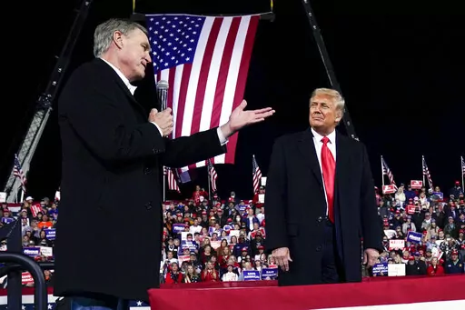 Former Sen. David Perdue of Georgia, speaks as President Donald Trump looks on, at a campaign rally at Valdosta Regional Airport, Dec. 5, 2020, in Valdosta, Ga. Perdue is building his campaign around Donald Trump and veering to the right as he tries to unseat Republican Gov. Brian Kemp in a May 24 GOP primary. (AP Photo/Evan Vucci, File)