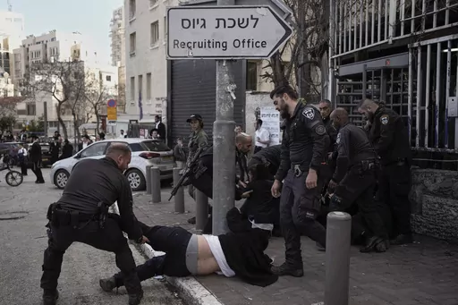 Israeli police officers scuffle with ultra-Orthodox Jewish men during a protest against possible changes to the military draft laws, outside a military recruitment office in Jerusalem, on March 4, 2024. Israel's High Court ruling Thursday to curtail subsidies for ultra-Orthodox men has thrown Prime Minister Benjamin Netanyahu's political future into grave jeopardy. Netanyahu now has until Monday to present the court with a plan to dismantle what the justices called a system that privileges the u
