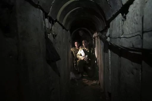Israeli soldiers walk through a tunnel discovered near the Israel-Gaza border Sunday, Oct. 13, 2013. An extensive labyrinth of tunnels built by Hamas stretches across the dense neighborhoods of the Gaza Strip, hiding militants, their missile arsenal and the over 200 hostages they now hold after an unprecedented Oct. 7, 2023, attack on Israel. (AP Photo/Tsafrir Abayov, File)