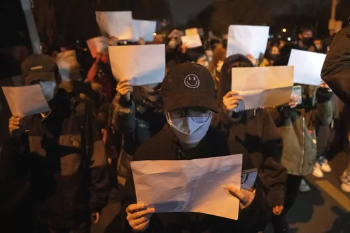 Protesters hold up blank pieces of paper and chant slogans as they march to protest strict anti-virus measures in Beijing, Nov. 27, 2022. Thousands of people demonstrated across China in what came to be called the White Paper movement, after the blank sheets of paper protesters used to represent the country's strict censorship controls. One year later, China has all but forgotten the protests. The state reacted quickly, breaking up the marches with arrests and threats and ending COVID-19 control