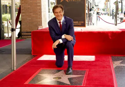 Mehmet Oz, the former host of "The Dr. Oz Show," poses atop his new star on the Hollywood Walk of Fame during a ceremony on Feb. 11, 2022, in Los Angeles. Oz may have made his reputation as a surgeon. But he made a fortune as a salesman on daytime TV. Now he is trying to leverage his celebrity as the Republican candidate in a bitterly contested U.S. Senate race in Pennsylvania. (AP Photo/Chris Pizzello, File)