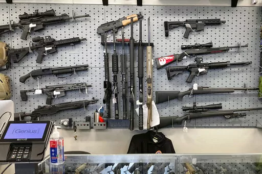 Firearms are displayed at a gun shop in Salem, Ore., on Feb. 19, 2021. An Oregon judge on Tuesday, Dec. 13, 2022, extended an earlier order blocking a key part of a new, voter-approved gun law and was hearing lengthy arguments on whether to also prevent the law's ban on high-capacity magazines from taking effect. (AP Photo/Andrew Selsky, File)