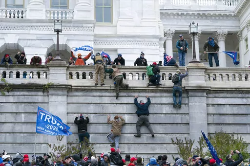 FILE - Violent insurrectionists loyal to then President Donald Trump climb the west wall of the the U.S. Capitol in Washington, Jan. 6, 2021. The House committee investigating the Jan. 6 insurrection at the Capitol has agreed to defer its request for hundreds of pages of records from the Trump administration, bending to the wishes of the Biden White House. (AP Photo/Jose Luis Magana, File)