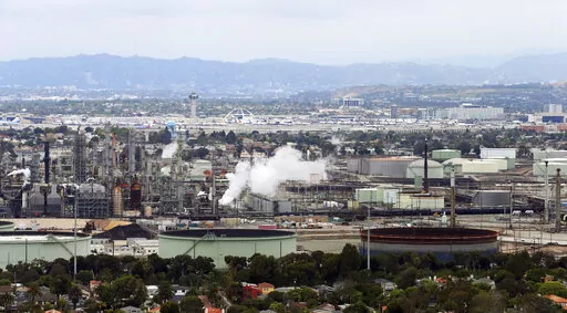 This aerial photo shows the Standard Oil Refinery in El Segundo, Calif., with Los Angeles International Airport in the background and the El Porto neighborhood of Manhattan Beach, Calif., in the foreground on May 25, 2017. California air regulators are set to approve an ambitious plan for the state to achieve carbon neutrality by 2045. Doing so will require a rapid transition away from oil and gas and toward renewable energy to power everything from cars to buildings. (AP Photo/Reed Saxon, File)