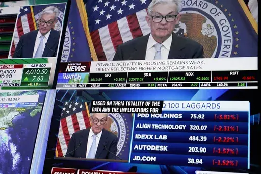 Displays show Fed chairman Jerome Powell's news conference while traders work on the floor at the New York Stock Exchange in New York, Wednesday, March 22, 2023. (AP Photo/Seth Wenig)