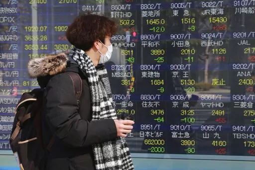 A man looks at an electronic stock board of a securities firm in Tokyo, Tuesday, Feb. 1, 2022. Asian shares gained Tuesday, mirroring broad overnight gains on Wall Street, while trading in China and most other regional markets was closed for Lunar New Year holidays. (AP Photo/Koji Sasahara)