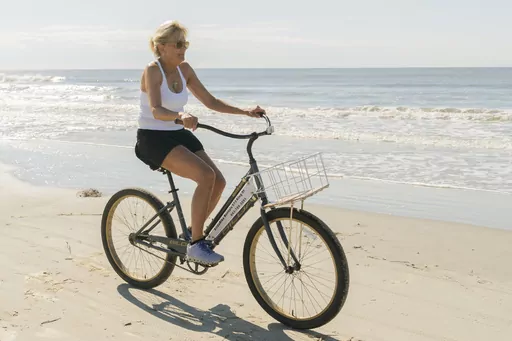 First lady Jill Biden rides a bicycle along the beach at Kiawah Island, S.C., Aug. 14, 2022. Jill Biden says exercise helps her find ‘inner strength.’ The first lady attends spin classes when she's on the road. She rides a bicycle near her Delaware beach home. She jogs on the White House driveway. Biden also takes barre classes and rides a Peloton bike. (AP Photo/Manuel Balce Ceneta, File)