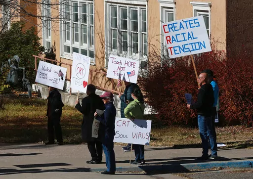 People protest outside the offices of the New Mexico Public Education Department's office, on Nov. 12, 2021, in Albuquerque, N.M. As conservative-run states across the U.S. move to restrict discussion of race, gender, and identity in the classroom, progressive-run states are trying to prioritize those discussions. In New Mexico, education officials are moving forward with a social studies curriculum that increases focus on identity, race and "privilege or systemic inequity." (AP Photo/Cedar Atta