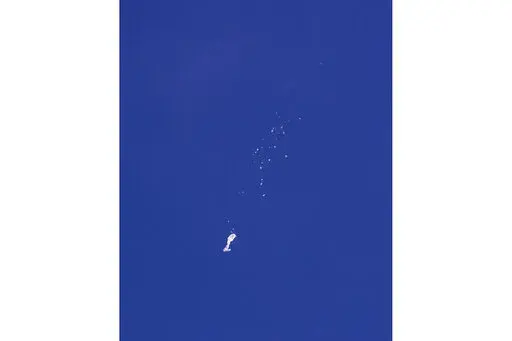 The remnants of a large balloon descend after it was struck by a missile from an F-22 fighter jet over the Atlantic Ocean, just off the coast of South Carolina near Myrtle Beach, Feb. 4, 2023. China's ceremonial parliament has accused American lawmakers of trampling on the sovereignty of other nations after the U.S. passed a measure condemning a suspected Chinese spy balloon's intrusion into U.S. airspace. (Chad Fish via AP, File)