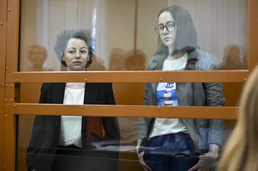 Theater director Zhenya Berkovich, left, and playwright Svetlana Petriychuk are seen in a glass cage prior to a hearing in a court in Moscow, Russia, Monday, May 20, 2024. Berkovich, a prominent independent theater director, and Petriychuk, a playwright have been behind bars since early May. Authorities claim a play they staged, "Finist, the Brave Falcon," justifies terrorism, which is a criminal offence in Russia punishable by up to seven years in prison. (AP Photo/Dmitry Serebryakov)