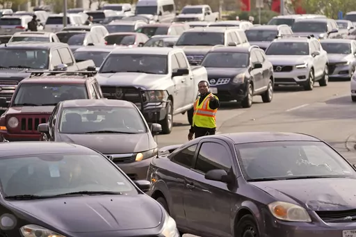 An officer directs traffic at Love Field Airport in Dallas, Wednesday, Dec. 21, 2022. The rate of people working from home dropped from 17.9% in 2021 to 15.2% in 2022, according to new survey data released Thursday, Sept. 14, 2023, by the U.S. Census Bureau on life in America, covering commuting times internet access, family life, income, education levels, disabilities, military service and employment. (AP Photo/LM Otero, File)