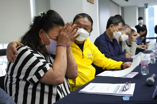 Park Sun-yi, left, a victim of Brothers Home, weeps during a press conference at the Truth and Reconciliation Commission office in Seoul, South Korea, Wednesday, Aug. 24, 2022. The commission has found the country's past military governments responsible for atrocities committed at Brothers Home, a state-funded vagrants' facility where thousands were enslaved and abused from the 1960s to 1980s. (AP Photo/Ahn Young-joon)