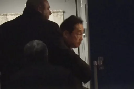 In this image made from video provided by Japan's NTV, Japanese Prime Minister Fumio Kishida gets on train in Przemysl, Poland, early Tuesday, March 21, 2023, heading to Kyiv for talks with Ukrainian President Volodymyr Zelenskyy. Kishida’s surprise trip to Ukraine comes just hours after he met with Indian Prime Minister Narendra Modi in New Delhi. (NTV via AP)