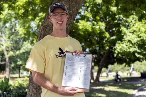 Nate Golden, president of the Maryland Child Alliance, poses for a portrait with a petition form for the Baltimore Baby Fund, Wednesday, July 3, 2024, in Baltimore. (AP Photo/Stephanie Scarbrough)