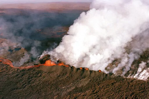 A gaseous cloud rises from the crater of Mauna Loa, center, on the big island of Hawaii, April 4, 1984. The ground is shaking and swelling at Mauna Loa, the largest active volcano in the world, indicating that it could erupt. Scientists say they don't expect that to happen right away but officials on the Big Island of Hawaii are telling residents to be prepared in case it does erupt soon. (AP Photo/John Swart, File)