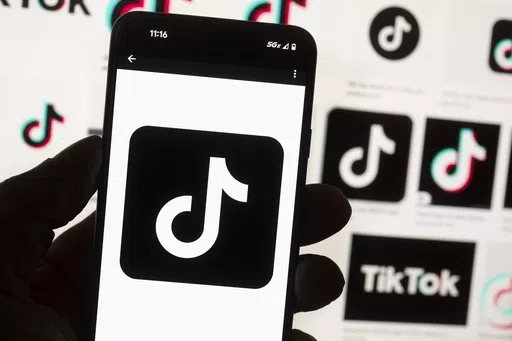 The TikTok logo is displayed on a mobile phone in front of a computer screen, Oct. 14, 2022, in Boston. On Tuesday, May 7, 2024, TikTok and its Chinese parent company ByteDance filed suit against the U.S. federal government to challenge a law that would force the sale of ByteDance's stake or face a ban, saying that the law is unconstitutional. (AP Photo/Michael Dwyer, File)