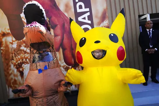Demonstrators dressed up in a dinosaur and Pikachu participate in an event protesting the use of fossil fuels at the COP27 U.N. Climate Summit, Wednesday, Nov. 9, 2022, in Sharm el-Sheikh, Egypt. (AP Photo/Peter Dejong)
