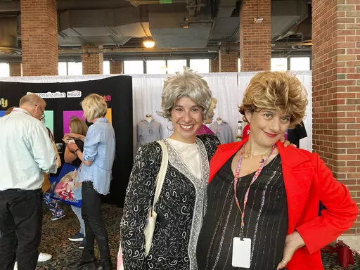 Hillary Wasicek and Melissa Gluck, sisters, pose as the characters Dorothy and Blanche at a "Golden Girls" fan convention in Chicago, Friday, April 22, 2022. Golden-Con, which lasts thru Sunday, is giving those who adored the NBC sitcom a chance to mingle, see panels and buy merchandise. The show, which ran from 1985-1992, starred Bea Arthur, Rue McClanahan, Estelle Getty and Betty White—who died at age 99 in December. (AP Photo/Terry Tang)