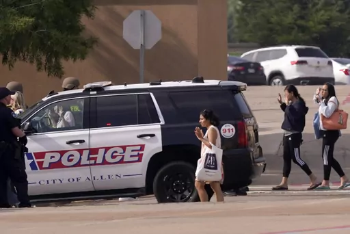 People raise their hands as they leave a shopping center after a shooting May 6, 2023, in Allen, Texas. Police released video footage Wednesday, June 28, of an officer killing a neo-Nazi gunman, quickly ending a mass shooting that left eight people dead and seven others wounded at the mall. The edited five-and-a-half-minute video details the final moments of Mauricio Garcia, 33, after he unleashed a rain of bullets from an AR-15-style rifle. (AP Photo/LM Otero, File)