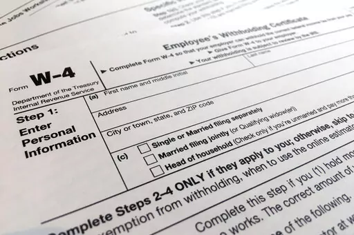 A W-4 form on Feb. 5, 2020, in New York. Monday is Tax Day, the federal deadline for individual tax filing and payments. The IRS will receive tens of millions of filings electronically and through paper forms. (AP Photo/Patrick Sison, File)