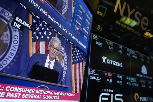 A screen displays a news conference with Federal Reserve Chairman Jerome Powell on the floor at the New York Stock Exchange in New York, May 1, 2024. On Wednesday, June 12, 2024, the Federal Reserve ends its latest meeting by issuing a policy statement, updating its economic and interest-rate projections and holding a news conference with Powell. (AP Photo/Seth Wenig, File)