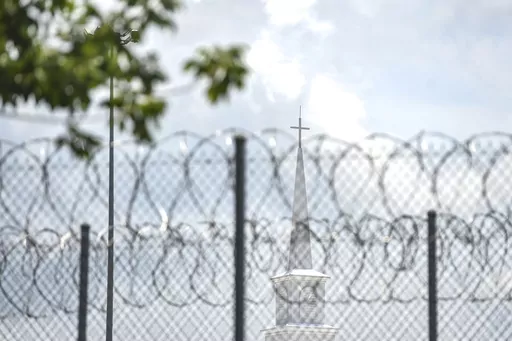 A church steeple peaks over the barbed-wire fence following the dedication of the newly constructed chapel at the Mississippi Correctional Institute for Women (MCIW) at Central Mississippi Correctional Facility in Pearl, Miss., June 15, 2023. A former Mississippi prison guard on Thursday, July 27, pleaded guilty to deprivation of an inmate's rights by using excessive force when she was a corrections officer at the Central Mississippi Correctional Facility, the U.S. Justice Department said. (Hann