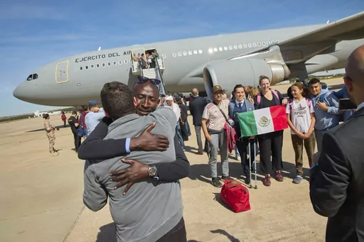 In this photo provided by the Spanish Defence Ministry passengers from Sudan disembark from a Spanish Air Force aircraft at Torrejon Air Base in Madrid, Monday April. 24, 2023. (Spanish Defence Ministry via AP)