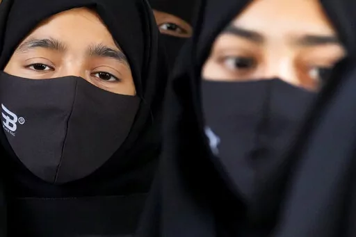 Indian Muslim students wearing hijabs and face masks gather to meet student activists in Kundapur in district Udupi, Karnataka state, India, Saturday, Feb. 26, 2022. An Indian court ruling upholding a ban on Muslim students wearing head coverings in schools has sparked criticism from constitutional scholars and rights advocates amid concerns of judicial overreach regarding religious freedoms. (AP Photo/Aijaz Rahi)