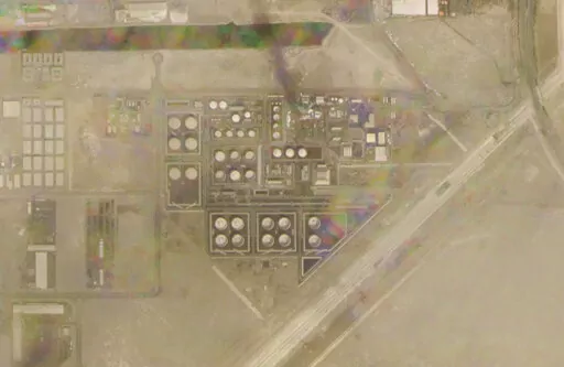 In this satellite image provided by Planet Labs PBC, smoke rises over an Abu Dhabi National Oil Co. fuel depot in the Mussafah neighborhood of Abu Dhabi, United Arab Emirates, Monday, Jan. 17, 2022. A drone attack claimed by Yemen's Houthi rebels targeting a key oil facility in Abu Dhabi killed three people on Monday and sparked a fire at Abu Dhabi's international airport. (Planet Labs PBC via AP)