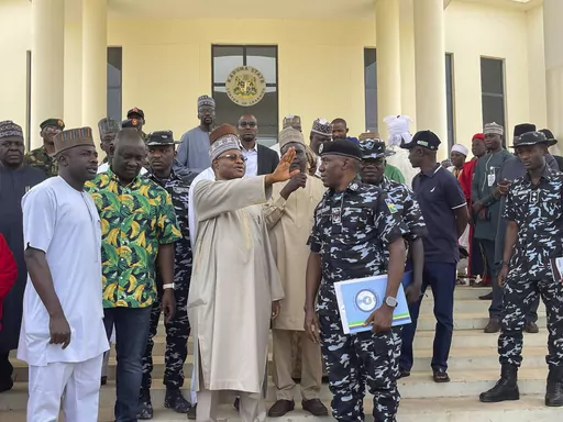 Kaduna state governor Uba Sani, centre, gestures after a meeting with security officers in Kaduna, Nigeria, Sunday, March 24, 2024. Officials in Nigeria say over 130 of nearly 300 schoolchildren have been released more than two weeks after they were seized in the northwestern state of Kaduna and marched into the forests. Sani, who first announced the rescue, did not give details about the operation. (AP Photo/Chinedu Asadu)