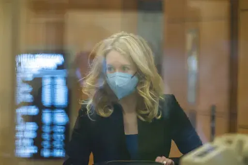 Elizabeth Holmes walks into federal court in San Jose, Calif., Monday, Nov. 22, 2021. Holmes is accused of duping elite financial backers, customers and patients into believing that her startup was about to revolutionize medicine. (AP Photo/Nic Coury)
