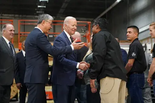 President Joe Biden tours SK Siltron CSS, a computer chip factory in Bay City, Mich., Tuesday, Nov. 29, 2022, with SK Siltron CSS CEO Jianwei Dong, second left. (AP Photo/Patrick Semansky)