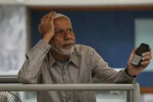 A dejected investor waits to restart trading, suspended for an hour following a 5% drop in in its main index, at the Pakistan Stock Exchange (PSE), in Karachi, Pakistan, Monday, April 7, 2025. (AP Photo/Fareed Khan)